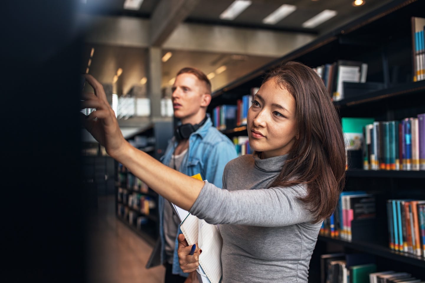 University students taking book from shelf in pz7ehfg | brainchamptech